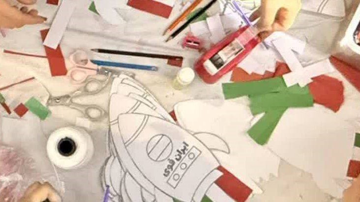 غرفه کتابخانه شهید رجایی با پرچم‌های برافراشته، مسیر رژه را رنگ‌آمیزی کرد